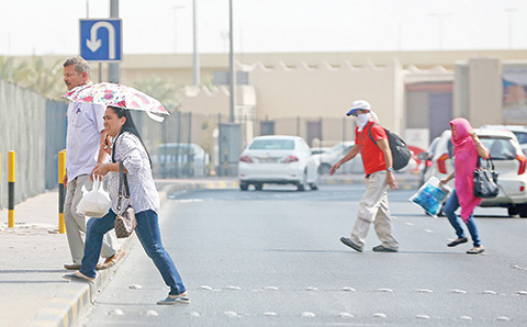 KUWAIT: Pedestrians brave the blazing sun amid a heat wave that has raised temperatures to unprecedented levels. A recent international report identified Kuwait as one of the hottest spots on earth this year. ñ Photo by Yasser Al-Zayyat