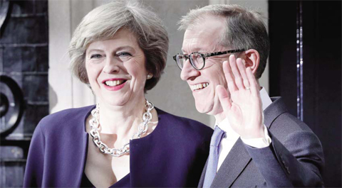 LONDON: Britain’s new Prime Minister Theresa May (L) and her husband Philip John wave outside 10 Downing Street on Wednesday.—AFP