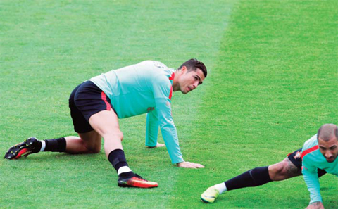 PARIS: Portugal’s Christiano Ronaldo stretches during a training session in Marcoussis, near Paris, France, yesterday. Portugal will face Wales in a Euro 2016 semi final soccer match in Lyon tomorrow. —AP