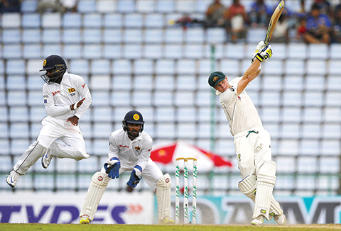 Australia's Steve Smith plays a shot as Sri Lankan fielder Kaushal Silva jumps on day four of the first test cricket match between Sri Lanka and Australia in Pallekele, Sri Lanka, Friday, July 29, 2016. (AP Photo/Eranga Jayawardena)