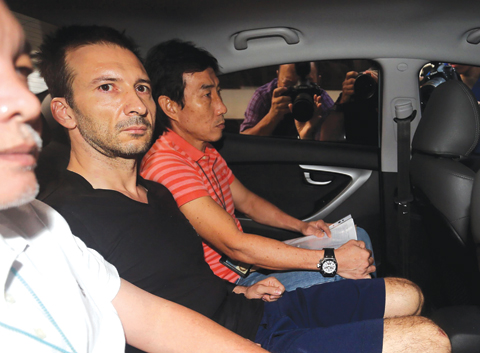 SINGAPORE: Belgian expatriate Philippe Graffart (center) arrives in a police car at the State court in Singapore. A Belgian expatriate was sentenced to five years’ jail in Singapore yesterday for killing his fiveyear- old son last year while suffering from severe depression during a child custody battle. —AFP