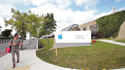 CORK, Southern Ireland: A man passing by buildings on The Apple campus in Cork, southern Ireland. — AFP