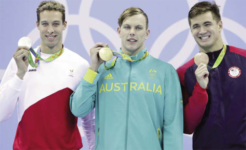 RIO DE JANEIRO: Australia’s gold medal winner Kyle Chalmers is flanked by Belgium’s silver medal winner Pieter Timmers, left, andnUnited States’ bronze medal winner Nathan Adrian during the men’s 100-meter freestyle medals ceremony during the swimming competitionsnat the 2016 Summer Olympics, yesterday. —AP