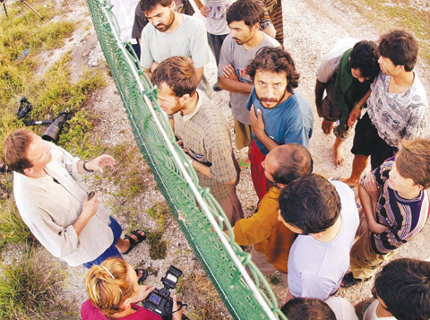 In this Sept 19, 2001, file photo, refugees, right, gather on one side of a fence to talk with international jounalists about their journey that brought them to the Island of Nauru. — AP