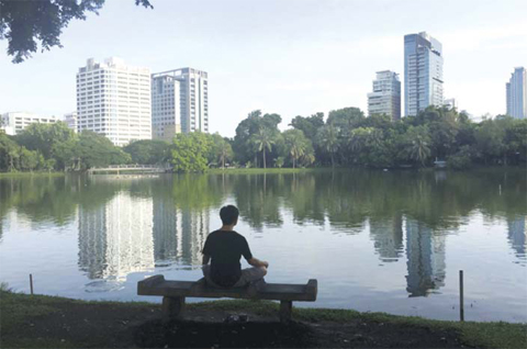 BANGKOK: A man meditates on a bench in front of a lake in Lumphini Park in Bangkok, Thailand. The park is in the heart of the main business district in Thailand’s capital and is frequented by joggers and other city dwellers looking for urban green space. —AP