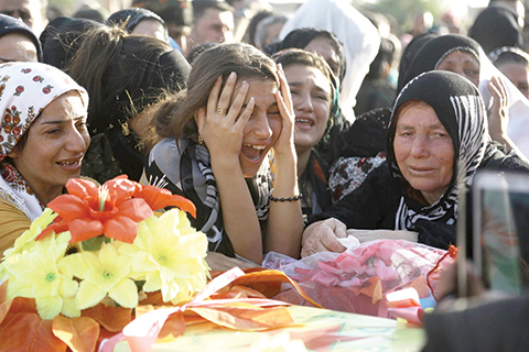 Women in the Kurdish-controlled city of Qamishly on August 13, 2016, mourn over a coffin during the funeral of several fighters from an Arab-Kurdish alliance, who were killed during battles with the Islamic State group (IS) in the northern Syrian city of Manbij. The last remaining IS fighters abandoned Manbij near the Turkish border the previous day and released hundreds of civilians they used as human shields while fleeing the crumbling stronghold. n n / AFP / DELIL SOULEIMAN