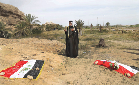 TIKRIT: In this April 3, 2015 file photo, an Iraqi man prays for his slain relative, at the site of a mass grave, believed to contain the bodies of Iraqi soldiers killed by Islamic State group militants when they overran Camp Speicher military base. — AP