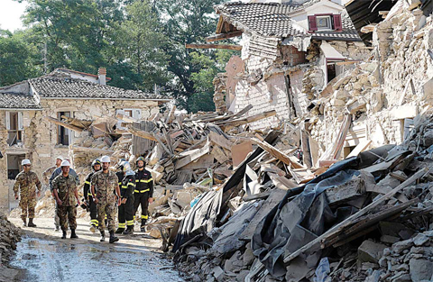 AMATRICE: Italian firefighters and soldier walk amid ruins during operation aiming at reopening the road in Rio, a little village near Amatrice, central Italy two days after a 6.2-magnitude earthquake struck the region killing some 267 people and injuring at least 367 people. —AFP