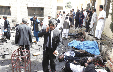 Pakistani lawyers and security officials gather around the bodies of victims of a bomb explosion at a government hospital premises in Quetta on August 8, 2016.