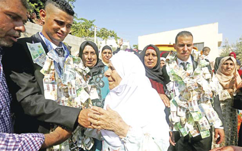 The grandmother of Fayez Msallem (center) congratulates him during his wedding ceremony.
