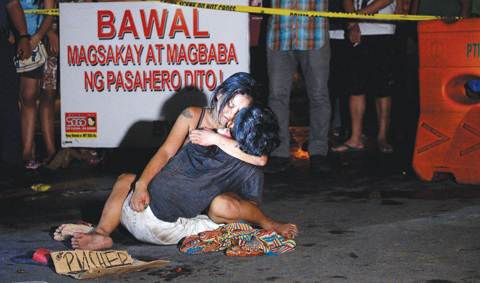 MANILA: This file photo shows Jennilyn Olayres hugging the dead body of her partner Michael Siaron who was shot by unidentified gunman and left with a cardboard sign with a message “I’m a pusher” along a street in Manila. —AFP