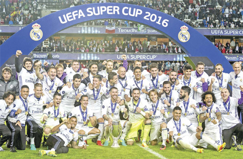 TRONDHEIM: Real Madrid’s team members pose with the trophy after defeating Sevilla in the Super Cup 2016 soccer match in Trondheim, Norway, Tuesday. — AP