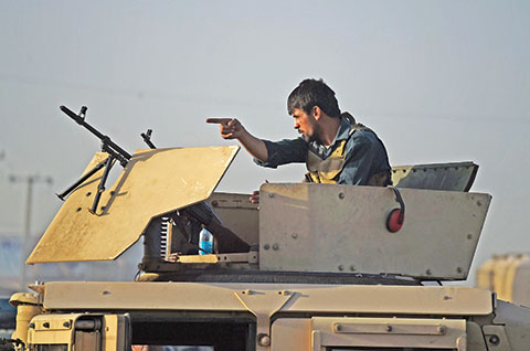 TOPSHOT - An Afghan policeman keeps watch near the site where a truck bomb exploded targeting a hotel used by foreign contractors, on the outskirts of Kabul on August 1, 2016.nA massive Taliban truck bomb struck a hotel for foreigners on the outskirts of Kabul early on August 1, officials said, just days after the deadliest attack in the Afghan capital for 15 years. / AFP PHOTO / WAKIL KOHSAR