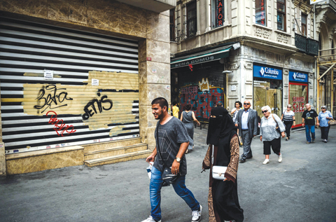 ISTANBUL: People pass by closed shops as they walk down the Istiklal avenue on in Istanbul. - AFP 