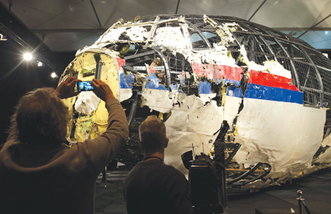 GILZE-RIJEN, CENTRAL NETHERLANDS: In this Tuesday, Oct. 13, 2015 file photo, journalists take images of part of the reconstructed forward section of the fuselage after the presentation of the Dutch Safety Board’s final report into what caused Malaysia Airlines Flight 17 to break up high over Eastern Ukraine last year, killing all 298 people on board, during a press conference.—AP
