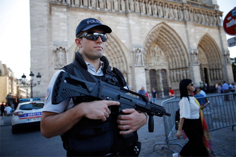 A French police officer patrols in front of Notre Dame cathedral, in Paris, Friday Sept. 9, 2016. (AP Photo/Christophe Ena) 
