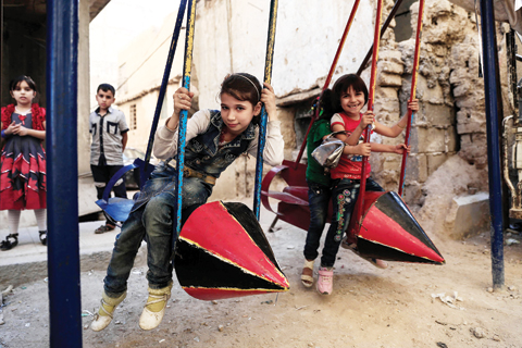 DOUMA, Syria: Syrian children play on swings made from the remnants of exploded rockets in this rebel-held town on the eastern edges of the capital Damascus on Sept 14, 2016, on the third day of Eid Al-Adha. - AFP 