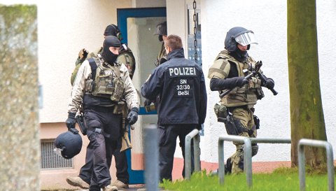 CHEMNITZ, GERMANY: Police officers leave an apartment after detonations in the eastern city on Saturday. —AP