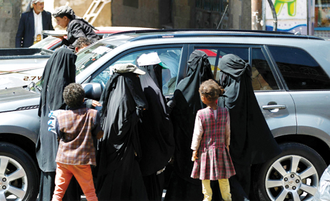 SANAA: Yemenis beg drivers for money on a street yesterday. —AFP