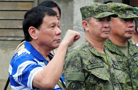 Philippines' President Rodrigo Duterte gestures a clenched fist as he visit soldiers in Butig, Lanao del Sur, southern Philippines November 30, 2016. REUTERS/Stringer