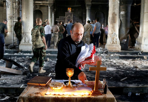 An Iraqi Christian prepares for the first Sunday mass at the Grand Immaculate Church since it was recaptured from Islamic State in Qaraqosh, near Mosul in Iraq, October 30, 2016 Photo: Reuters/Ahmed Jadallah