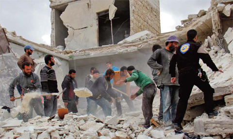 IDLIB, Syria: Rescuers and civilians inspect a destroyed building in the Syrian village of Kfar Jales, on the outskirts of Idlib, following air strikes by Syrian and Russian warplanes yesterday. — AFP