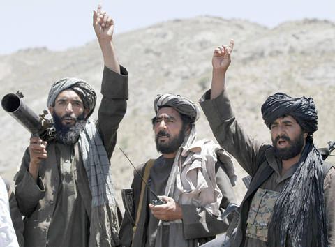 HERAT: Taleban fighters react to a speech by their senior leader in the Shindand district of Herat province, Afghanistan, in this file photo. — AP