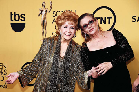 This file photo taken on January 25, 2015 shows actresses Debbie Reynolds (left), recipient of the Screen Actors Guild Life Achievement Award, and Carrie Fisher posing in the press room at the 21st Annual Screen Actors Guild Awards at The Shrine Auditorium in Los Angeles, California. — AP/AFP photos