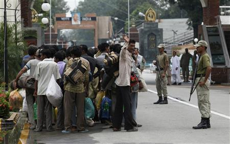 This is File Photo - Pakistani paramilitary soldiers stand guard as fishermen, who were released from a Pakistani jail, hold their belongings while they stand in a queue at the Wagah border, before crossing into India, on the outskirts of Lahore August 24, 2013. REUTERS/Mohsin Razan