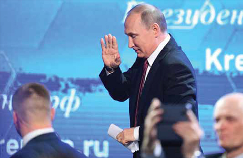 MOSCOW: Russian President Vladimir Putin waves as he leaves after his annual press conference in Moscow yesterday. — AFP