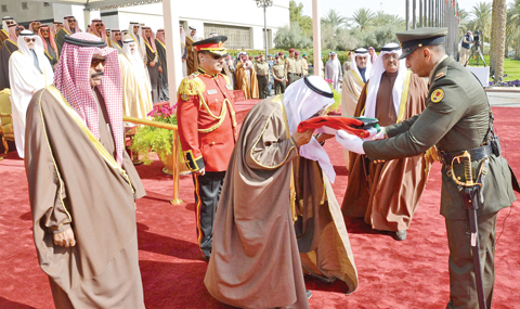 KUWAIT: HH the Amir Sheikh Sabah Al-Ahmad Al-Jaber Al-Sabah kisses the Kuwaiti flag yesterday at Bayan Palace during a flag hoisting ceremony marking the 11th year since he assumed power and the start of Kuwait’s 56th National Day and 26th Liberation Day anniversaries. HH the Crown Prince Sheikh Nawaf Al-Ahmad Al-Jaber Al-Sabah is seen at left. — KUNA