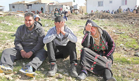 UMM AL-HIRAN: Bedouins cry following the destruction of houses yesterday in the Bedouin village of Umm Al-Hiran, which is not recognized by the Israeli government, near the southern city of Beersheba, in the Negev desert. — AFP