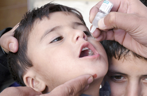 PAKISTAN: A Pakistani health worker gives polio vaccine to a child in Quetta yesterday.-AP