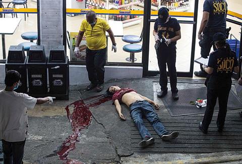 MANILA: Photo shows a body of an alleged drug user on the ground after unidentified gunmen shot him dead in Manila. —AFP