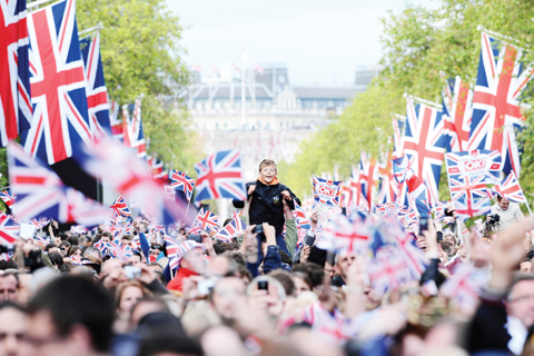LONDON: This file photo taken on June 4, 2012 shows a boy getting a boost to see the action from the Mall waiting for the start of the Queen’s Diamond Jubilee Concert at Buckingham Palace. — AFP