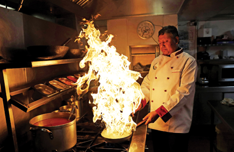 LONDON: Chef Mohammed Faizul Haque uses lemon juice to make flames as he demonstrates how to give a smokey flavour to dishes such as Kuchi Chilli Chicken at the Taste of India curry restaurant. — AP photos