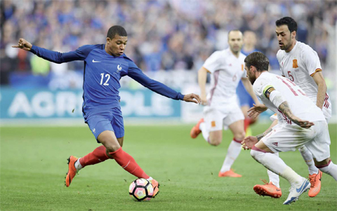 SAINT DENIS: Saint-Denis, Seine-Saint-Denis, France : TOPSHOT - France’s forward Kylian Mbappe vies with Spain’s midfielder Sergio Busquets and captain Sergio Ramos during their friendly football match France vs Spain at the stade de France in Saint Denis near Paris on Tuesday. —AFP