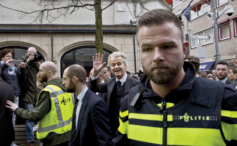 HEERLEN: Firebrand anti-Islam lawmaker Geert Wilders (second right) surrounded by police officers and security guards as he waves to supporters during a campaign stop in Heerlen, Netherlands. — AP