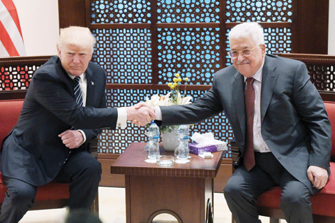 BETHLEHEM: US President Donald Trump shakes hands with Palestinian leader Mahmoud Abbas during a meeting at the presidential palace in this West Bank city yesterday. - AFP 