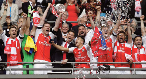 LONDON: Arsenal’s players celebrate with the trophy after winning the English FA Cup final soccer match between Arsenal and Chelsea at the Wembley stadium yesterday. — AP