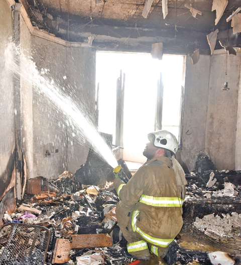 KUWAIT: A firefighter tackles a blaze in a building in Bneid Al-Gar yesterday