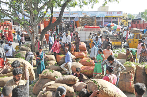 HYDERABAD: Indian traders and vendors negotiate prices of vegetables at a wholesale vegetable market in Hyderabad. India’s economic growth slowed to 7.1 percent for the 2016-17 financial year, according to official data released yesterday. — AFP