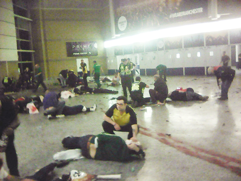 MANCHESTER: Helpers attend to injured people inside Manchester Arena after a blast late Monday. - AP 