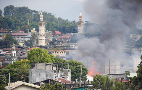MARAWI, Philippines: A fire rages in houses following air strikes by the Philippine Air Force yesterday. —AP