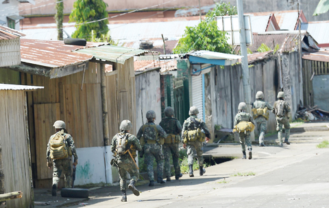 MARAWI: Philippine marines patrol a deserted street in Marawi on the southern island of Mindanao yesterday. — AFP