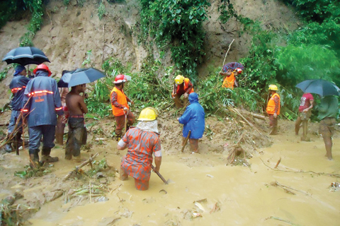 BANDARBAN: Bangladeshi fire fighters search for bodies after a landslide in Bandarban yesterday. — AFP