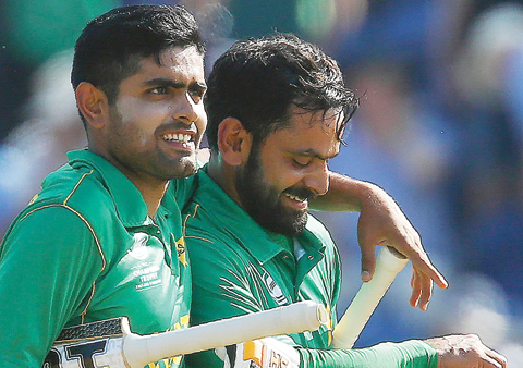 CARDIFF: Pakistan's Mohammad Hafeez (R) and Pakistan's Babar Azam walks back to the pavilion after Pakistan won the ICC Champions Trophy semi-final cricket match between England and Pakistan in Cardiff yesterday. Set just 212 for victory, Pakistan finished on 215 for two, with Azhar Ali (76) and Fakhar Zaman (57) sharing an opening partnership of 118. - AFP
