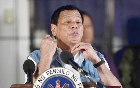 ILIGAN, Philippines: President Rodrigo Duterte gestures as he mimics “slitting of the throat” during a speech to evacuees from Marawi at an evacuation center in on the southern island of Mindanao yesterday. Duterte apologized for aerial bombings that have destroyed a large part of the Philippines’ main Muslim city, but said it was necessary to crush self-styled Islamic State followers. - AFP