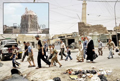 MOSUL: In this file photo, residents walk past the crooked minaret called Al-Hadba, or ‘hunchback’, in a busy market area in Mosul, Iraq. (Inset) An image grab from a video broadcasted by Iraq’s Al-Sumariya TV channel shows the base of Mosul’s trademark leaning minaret, known as the ‘Hadba’ (Hunchback), a day after it was destroyed by jihadists from the Islamic State (IS) group. —AFP photos