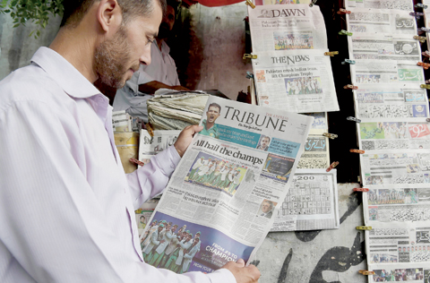 ISLAMABAD: A Pakistani man holds a morning newspaper with front page coverage of Pakistan’s victory against India in the ICC Champions Trophy final cricket match played in London, in Islamabad yesterday. Pakistani newspapers headlined the national cricket team’s victory against India, who they thrashed by 180 runs to win the Champions Trophy final at The Oval in London on Sunday. — AFP
